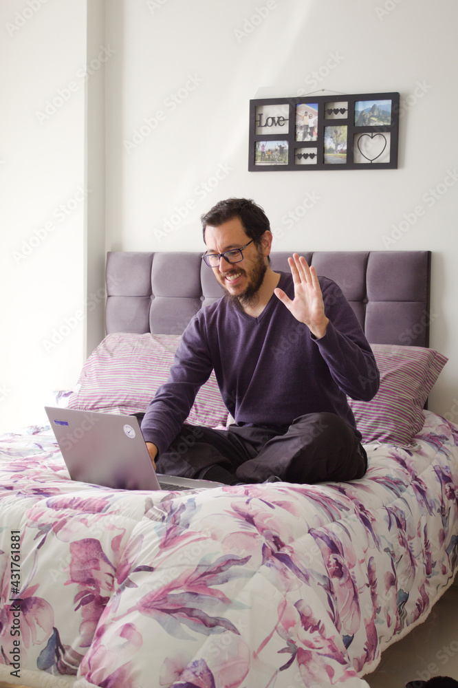 Happy man zapping and watching tv relaxing in the bed greating videoconference interview copy space
Happy man zapping and watching tv relaxing in the bed greating videoconference interview copy space