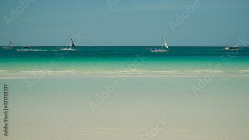Sandy tropical beach with boats and yachts and blue sea gainst the sky. Summer and travel vacation concept. © Alex Traveler