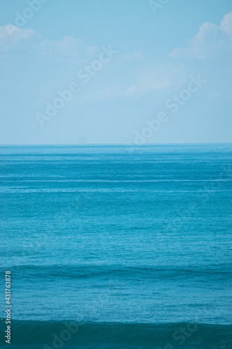 Ocean z falami i niebem, naturalne niebieskie tło.