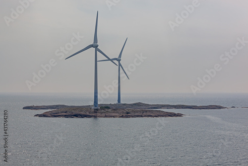 Picturesque wind turbines in fog on the small islet of Aland Archipelago, Finland