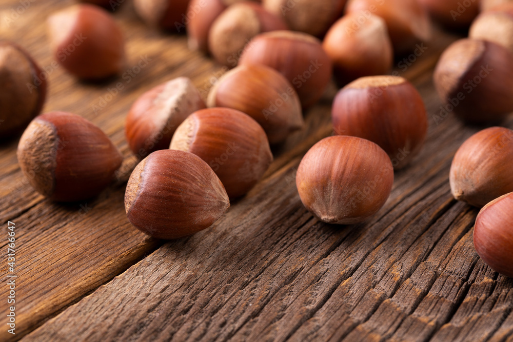 Whole young hazelnuts on a wooden table. Hazelnut tree and hazelnuts. A scattering of hazelnuts. Whole young hazelnuts on a wooden table. Hazelnut tree and hazelnuts. A scattering of hazelnuts.