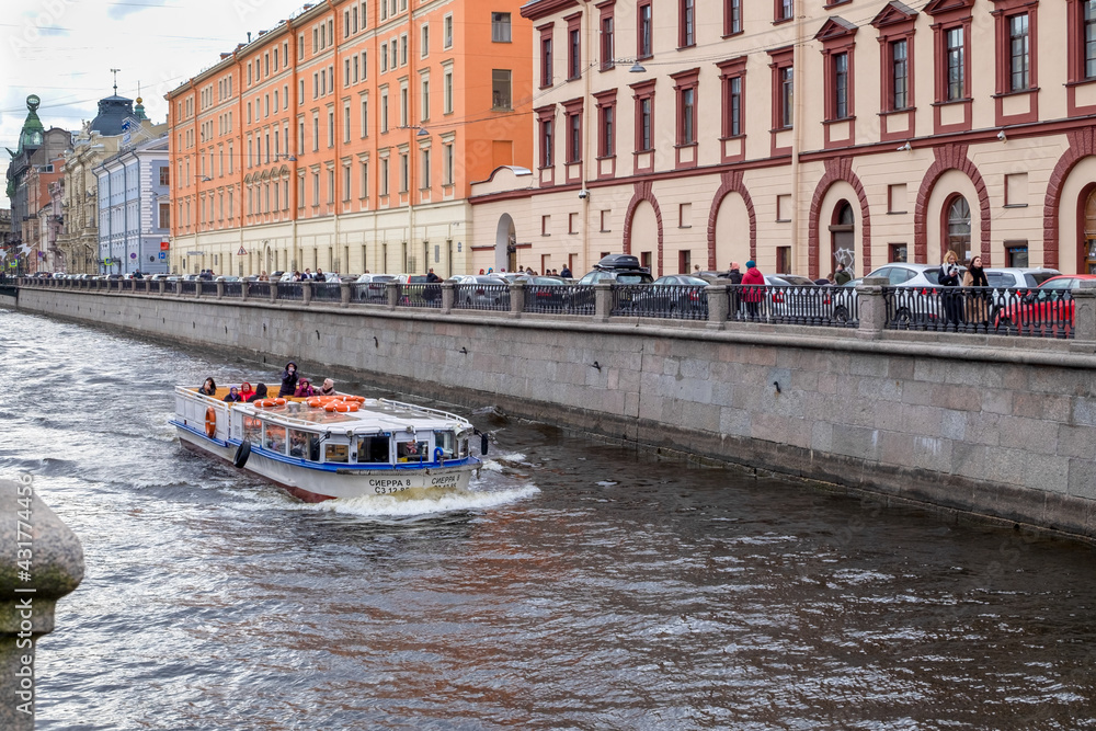 Obraz premium St. Petersburg, Russia - May 02, 2021. A pleasure boat sails along the Griboyedov Canal past historic buildings in the city center. Selective focus.