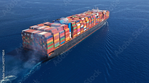 Aerial drone photo of huge container carrier tanker ship cruising deep blue open ocean sea photo