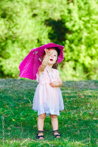 happy child with an umbrella in the park on the nature