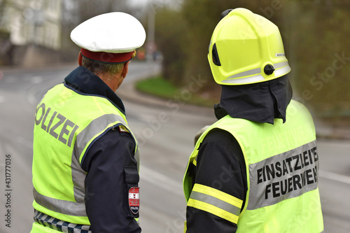 Polizist und Feuerwehrmann von hinten in Oberösterreich, Österreich, Europa - Police officer and firefighter from behind in Upper Austria, Austria, Europe