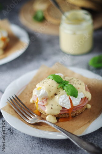 Egg benedict sandwiches - muffin with poached egg, ham and hollandaise sauce