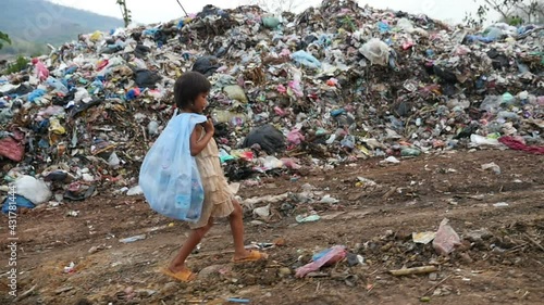 Poor Kid Carry Garbage Bag Walking, Garbage At Background
 photo