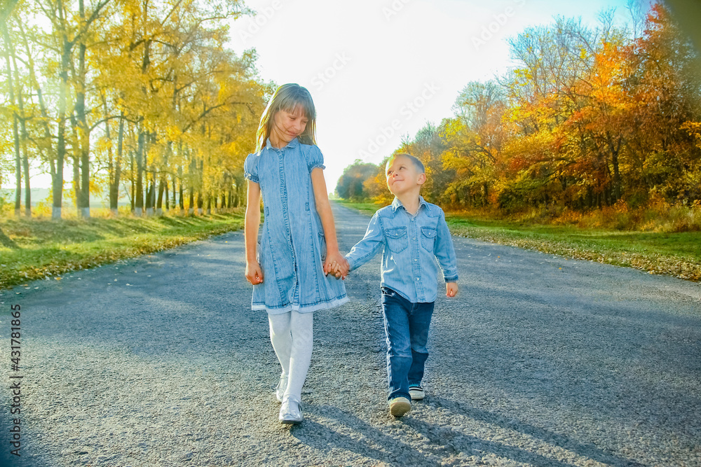 Fototapeta premium A Happy parent with child are walking along the road in the park on nature travel
