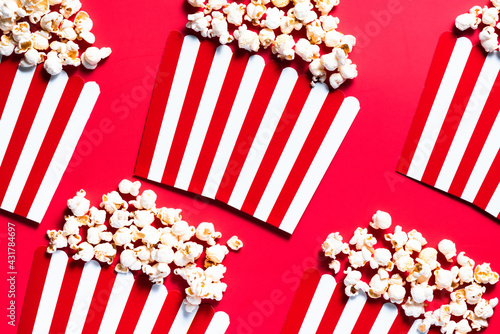 Striped Popcorn Bukcets on Red Background. Cinema and Movies Conccept. Flat Lay Box Officce Background © marcin jucha