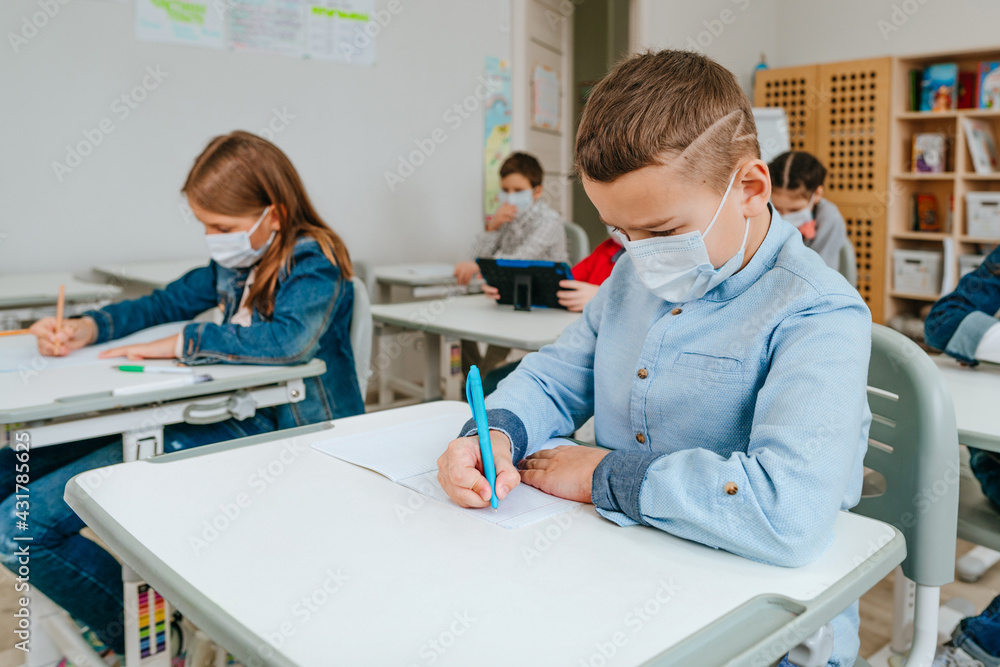 Fototapeta premium Elementary school students studying in the classroom during COVID-19 pandemic.