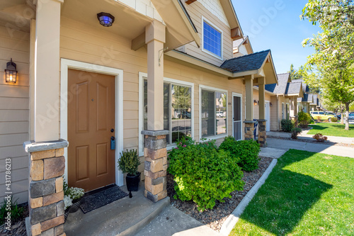 A home for sale with a lockbox on the doorknob within a row of suburban townhomes in the Inland Northwest. photo