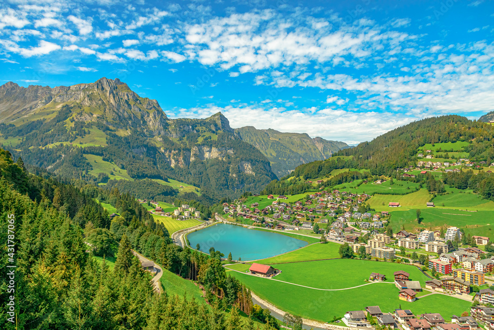Valley of Engelberg with Eugenisee lake. View from cable car to Titlis mountain of the Uri Alps. Located in cantons of Obwalden and Bern, Switzerland, Europe. Summer season, clear blue sky.
