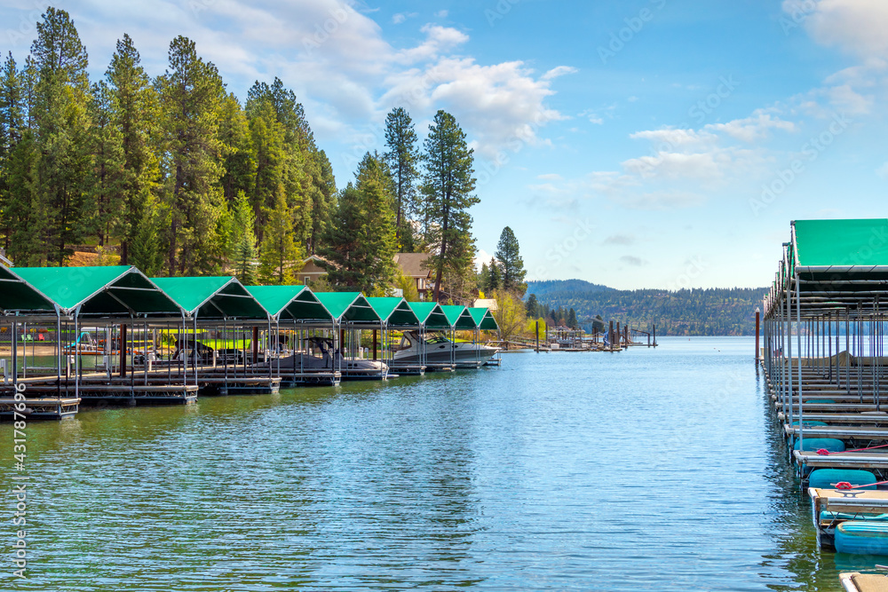 Fototapeta premium A row of docks with boat slips at Rockford Bay Black Rock Marina on the lake in the mountain resort town of Coeur d'Alene, Idaho, USA 