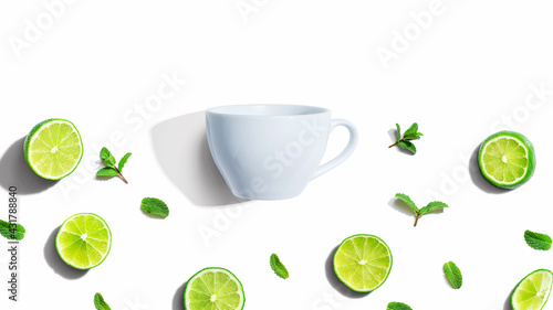 Fresh limes with tea cup overhead view