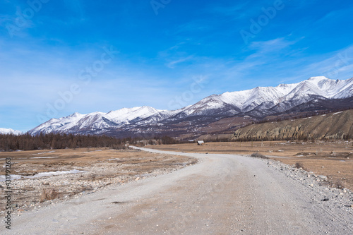 Valley of the Irkut River near the village of Mondy in early spring against the backdrop of the Tunkinskiye Goltsy. Republic of Buryatia, Russia, Siberia