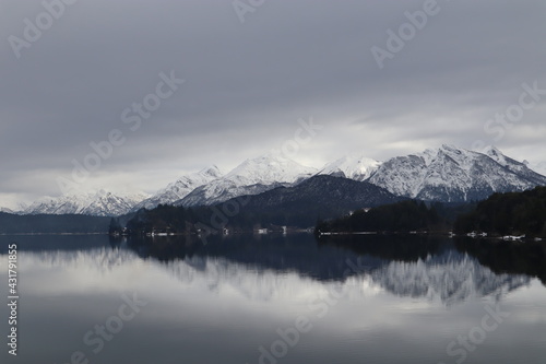 Crystal clear mountain lake in Patagonia, beautiful snowy mountain chain reflected in the calm water of the lake, with an astonishing mystical sky above, perfect place to meditate © Sarah Zezulka