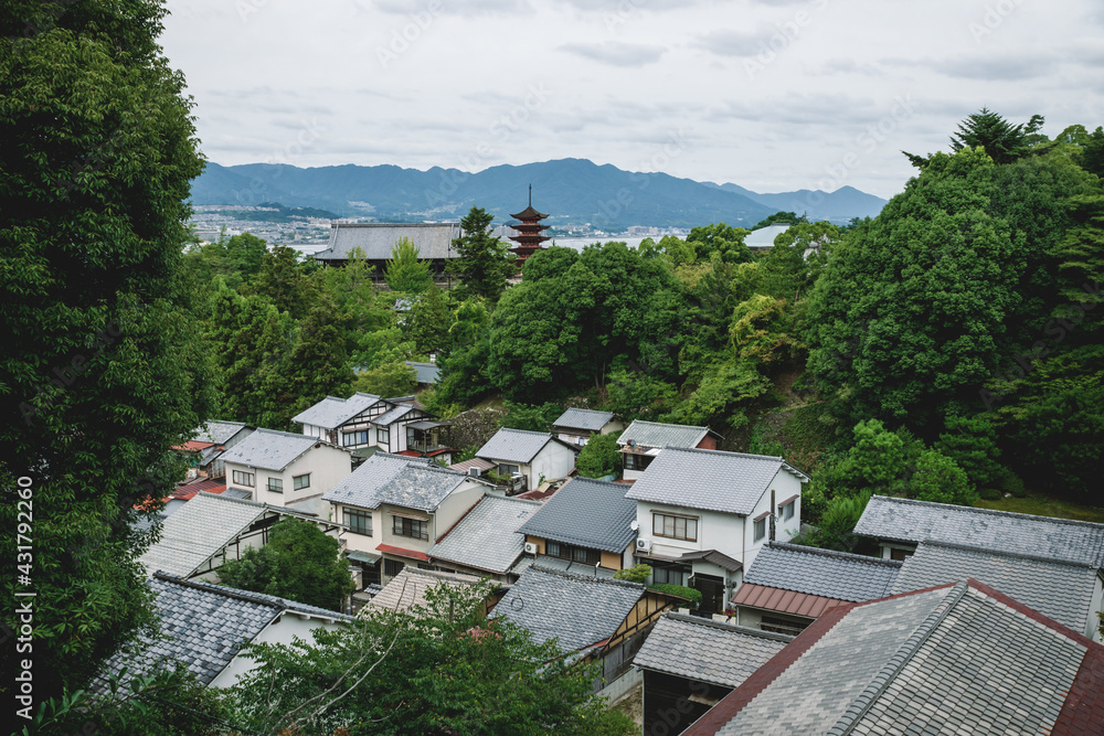 Aerial view over the roofs and five-story pagoda surrounded by forest of Miyajima, Japan