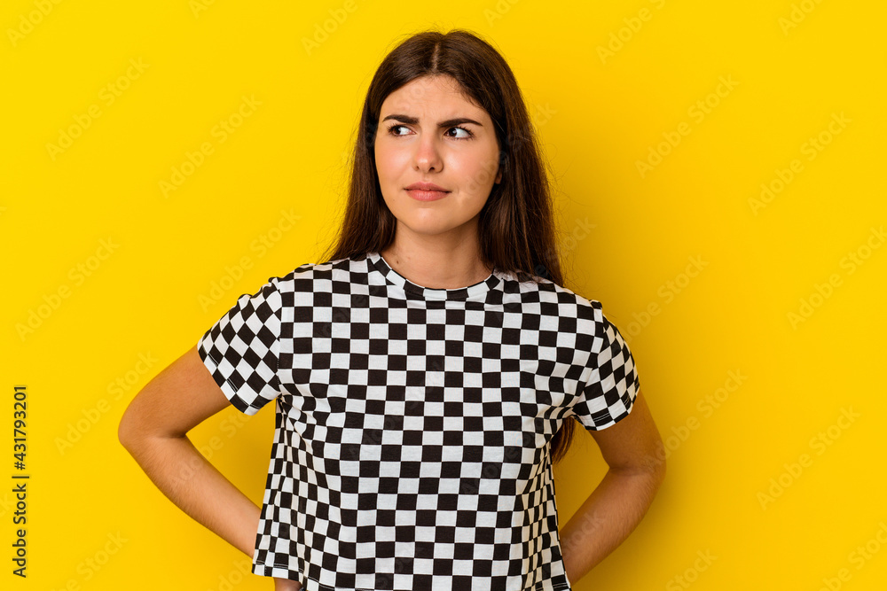 Young caucasian woman isolated on yellow background confused, feels doubtful and unsure. Young caucasian woman isolated on yellow background confused, feels doubtful and unsure.