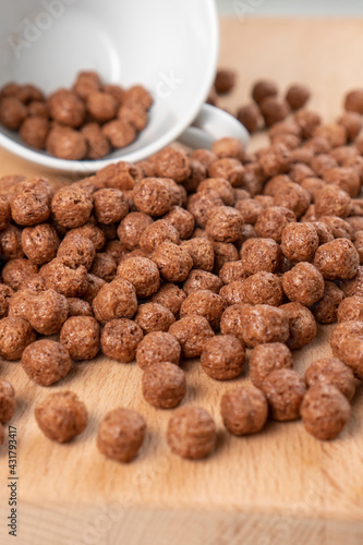 Crunchy chocolate cereal with white cup. Textured flakes balls