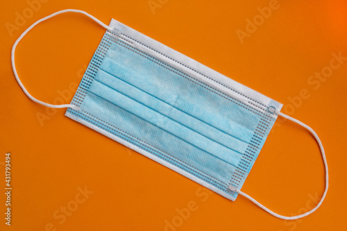 New medical protective surgical mask on a bright orange background