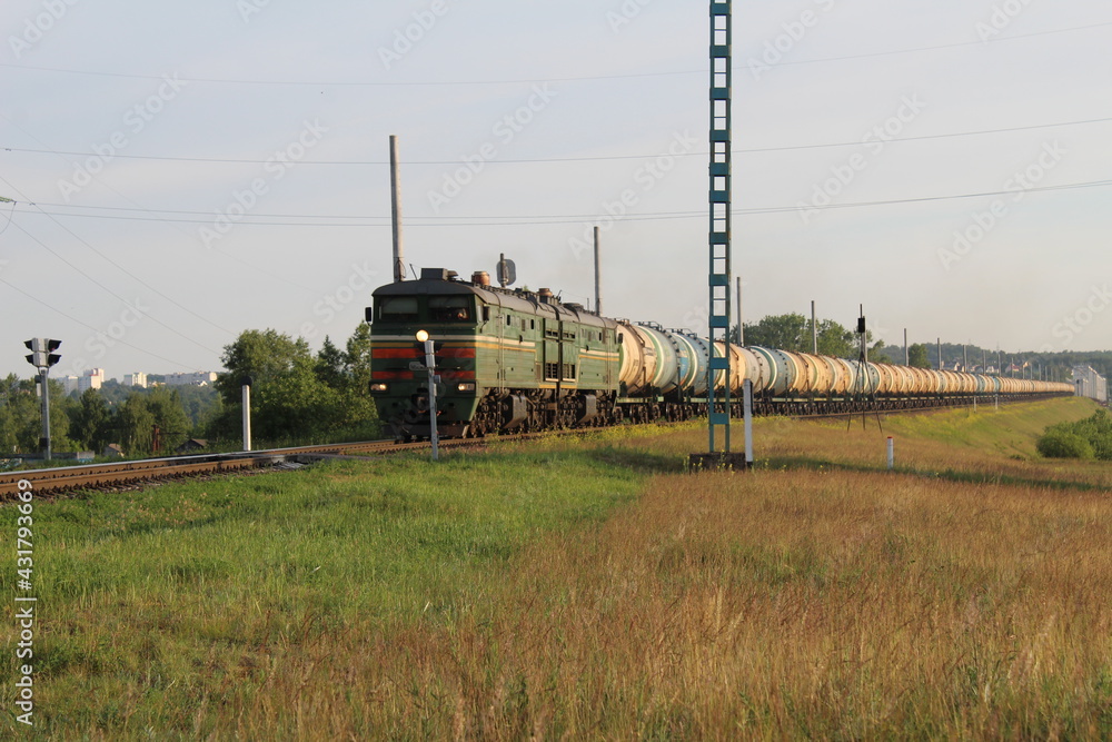 eating cargo rides among the grass meadows against the sky. Rail transport. Transport eating cargo rides among the grass meadows against the sky. Rail transport. Transport