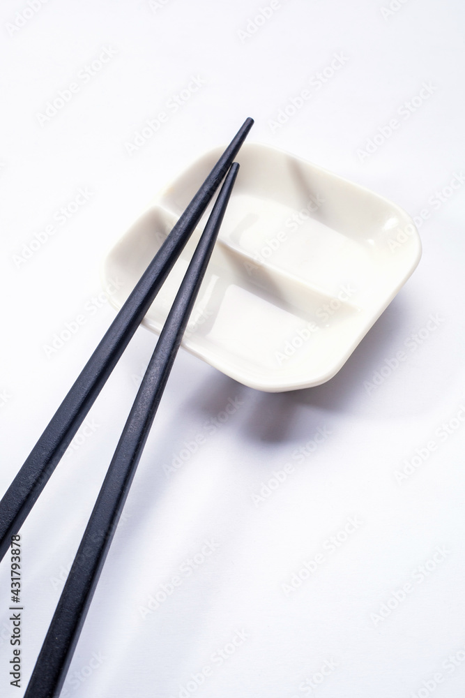 Black wooden sushi sticks with sauce saucer. View from above. Black wooden sushi sticks with sauce saucer. View from above.