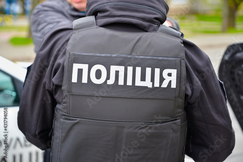 Patrol policeman. Ukraine. Word Police in Ukrainian on the back of the policeman’s uniform. 