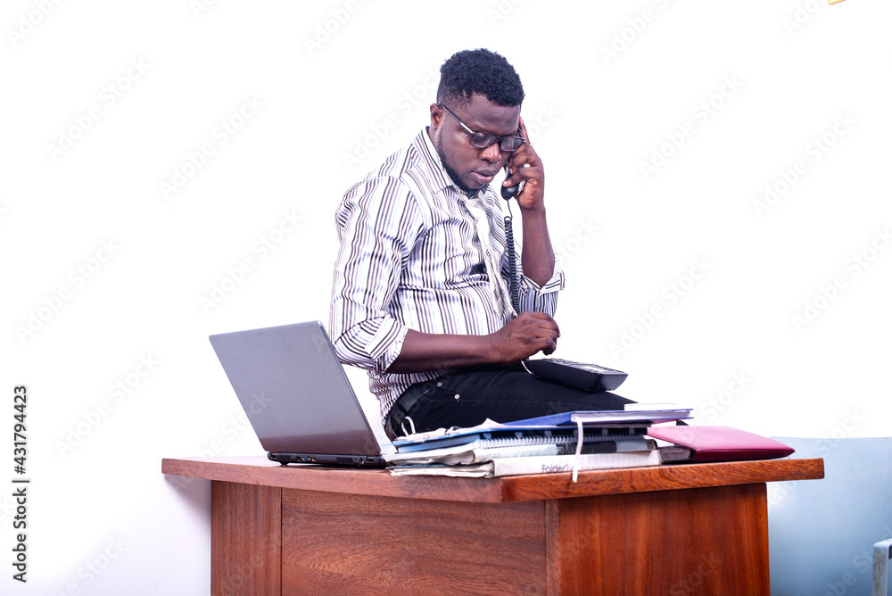 young serious businessman talking on mobile phone in office. young serious businessman talking on mobile phone in office.