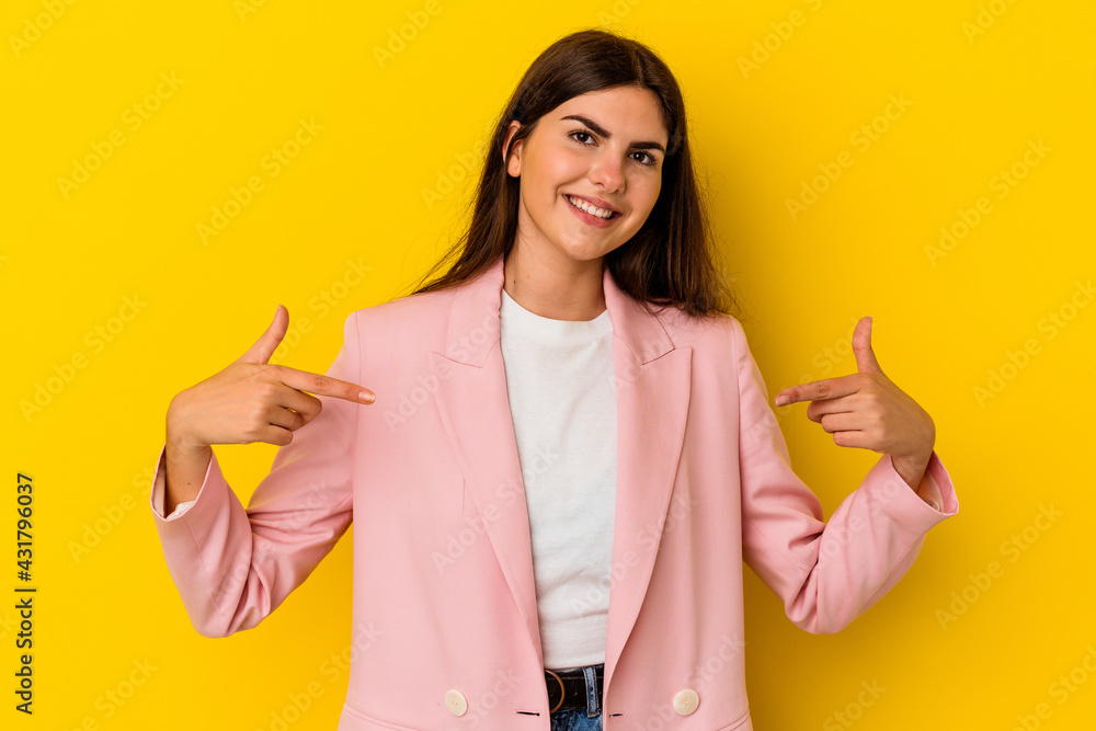 Young caucasian woman isolated on yellow background points down with fingers, positive feeling. Young caucasian woman isolated on yellow background points down with fingers, positive feeling.