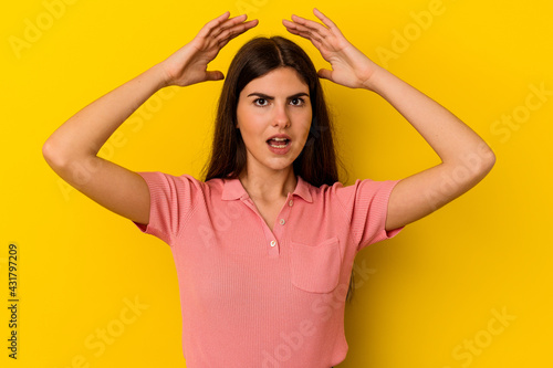 Young caucasian woman isolated on yellow background celebrating a victory or success, he is surprised and shocked.