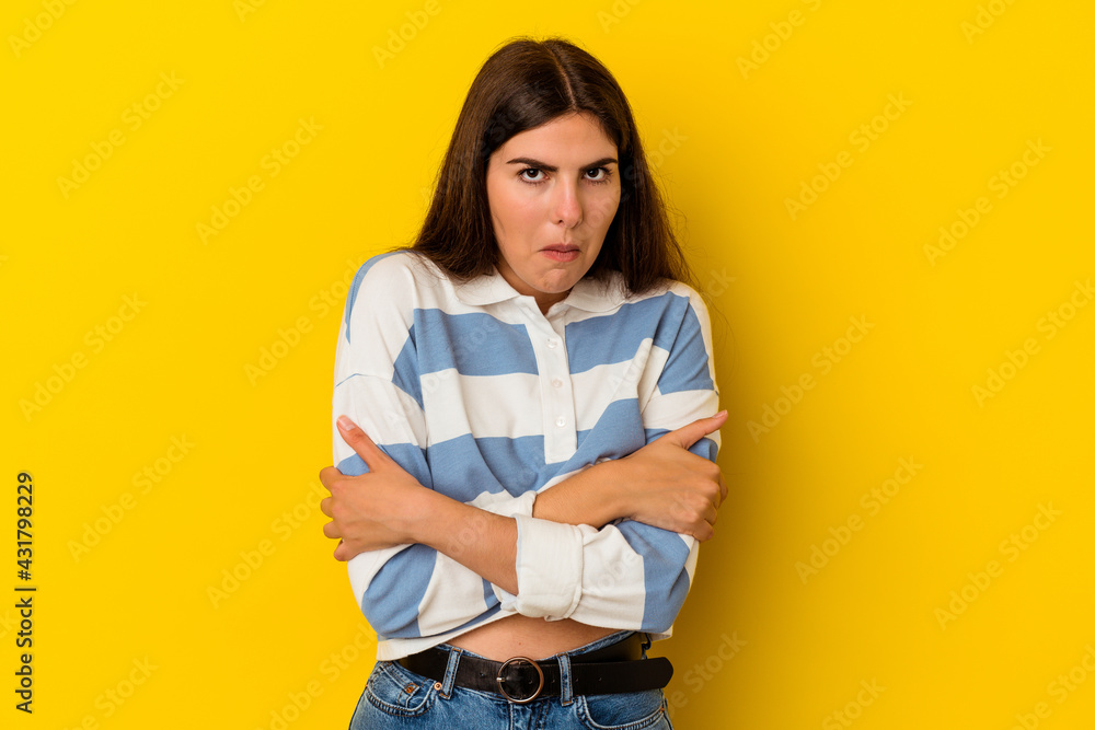 Young caucasian woman isolated on yellow background shrugs shoulders and open eyes confused. Young caucasian woman isolated on yellow background shrugs shoulders and open eyes confused.