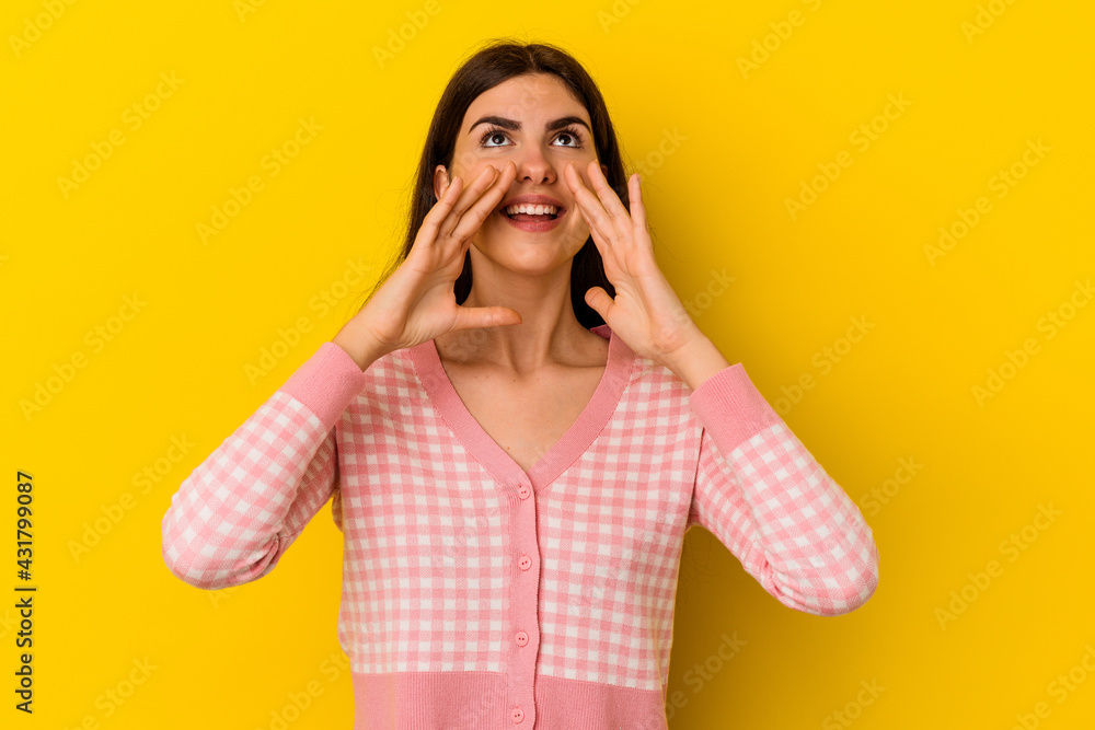 Young caucasian woman isolated on yellow background shouting excited to front. Young caucasian woman isolated on yellow background shouting excited to front.