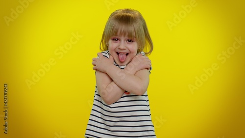 Come to me, I want to hug you. Funny playful blonde child girl 5-6 years old spread hands and give embrace to you. Pleasant expression love feelings on yellow studio wall background. Teen kid children