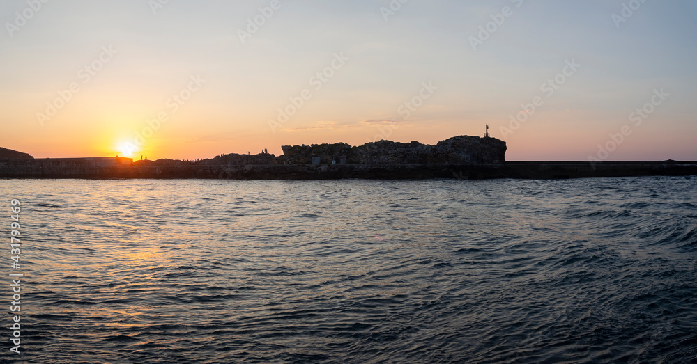 Vistas panorámicas de la puesta de sol con la silueta del puerto de San Vicente de la Barquera , Santander, España, en el verano de 2020