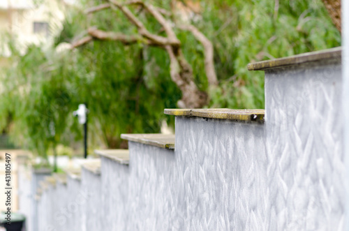 Detail of a house, boundary wall: in reinforced concrete. Step shape with wall painted in urban camouflage color. photo