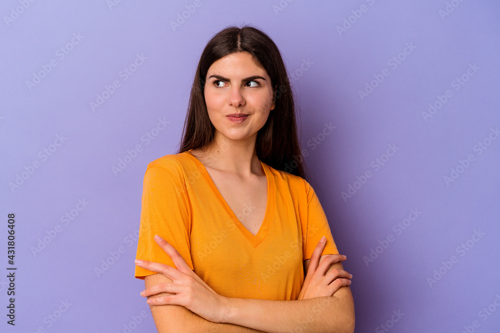 Obraz premium Young caucasian woman isolated on purple background dreaming of achieving goals and purposes