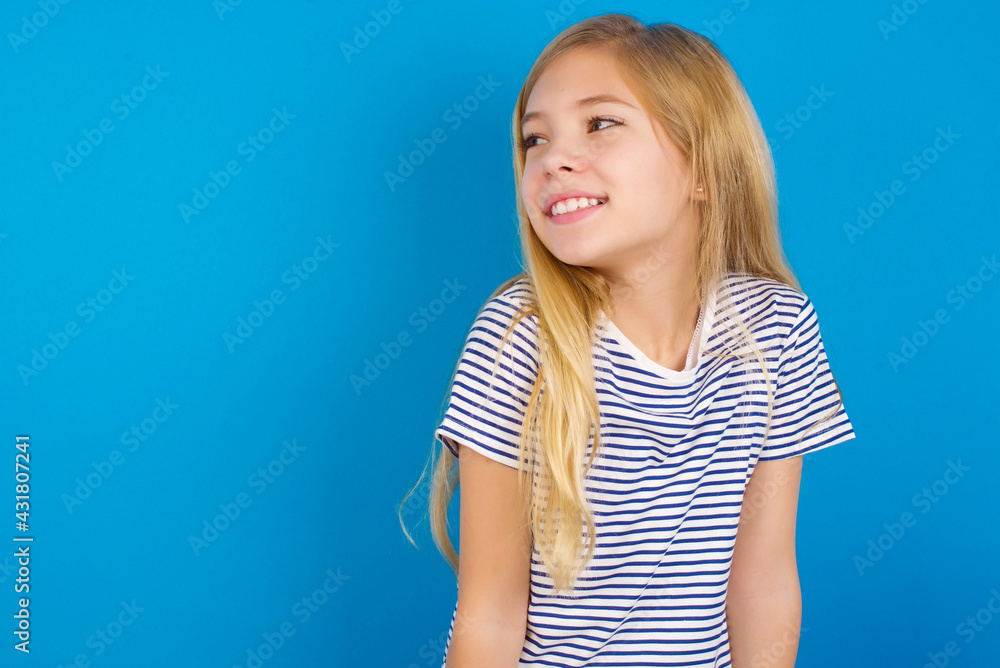 Caucasian kid girl wearing striped shirt against blue wall very happy and excited about new plans. Caucasian kid girl wearing striped shirt against blue wall very happy and excited about new plans.