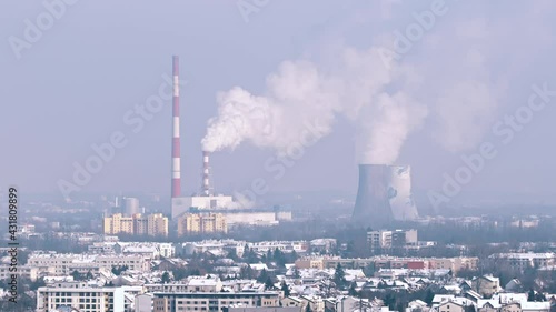 Panoramic view of the industrial area of Krakow from Krakus Mound. Smoke rises from the pipes of the thermal Power plant polluting the clear blue sky. Factories in the city. 