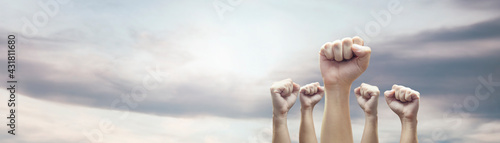 Man hands with clenched fist on sky background expressing freedom