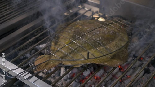 Grilled turbot with garlic and butter sauce, lemon and aromatic herbs