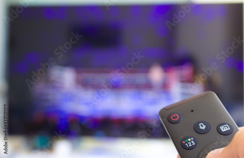 tv remote control close-up with boxing match blur background 