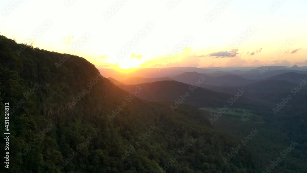 Time lapse aerial shot of a sunset close to a big mountain at Border Ranges National Park, New South Wales in Australia. Time lapse aerial shot of a sunset close to a big mountain at Border Ranges National Park, New South Wales in Australia.