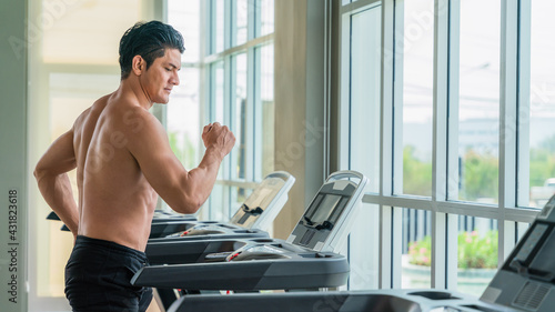 athletic man doing running exercise on treadmill in gym and fitness center