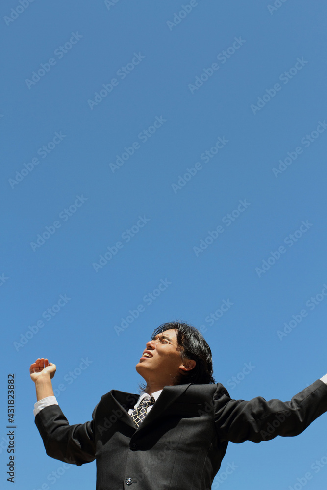 A young Japanese businessman stretching in a business district in Los Angeles, USA A young Japanese businessman stretching in a business district in Los Angeles, USA