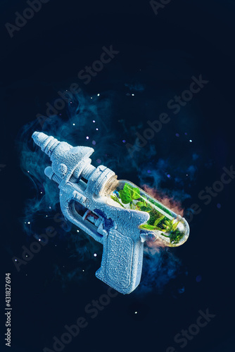 Fototapeta Naklejka Na Ścianę i Meble -  Frozen toy gun with a capsule of greenery inside, spring, rebirth, and vaccination concept