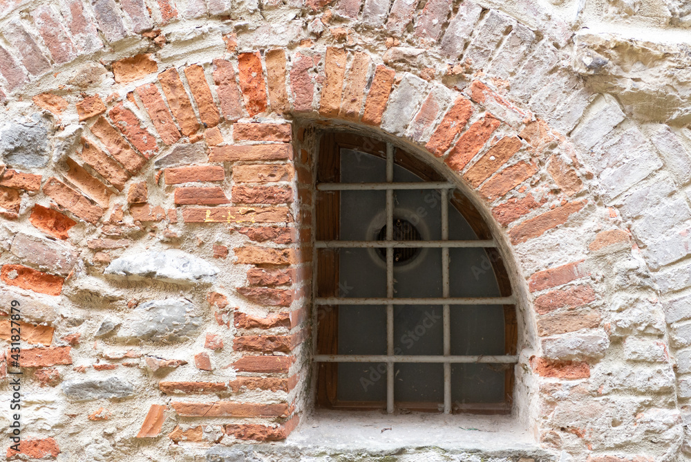 They laid a semicircular window with a brick. A walled-up window that's hundreds of years old. Masonry of old bricks. They laid a semicircular window with a brick. A walled-up window that's hundreds of years old. Masonry of old bricks.