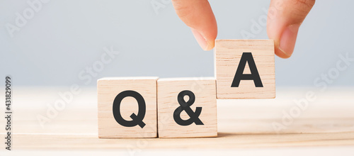 Hand holding Q and A word with wooden cube block. FAQ( frequency asked questions), Answer, Question  Ask, Information, Communication and Brainstorming Concepts photo