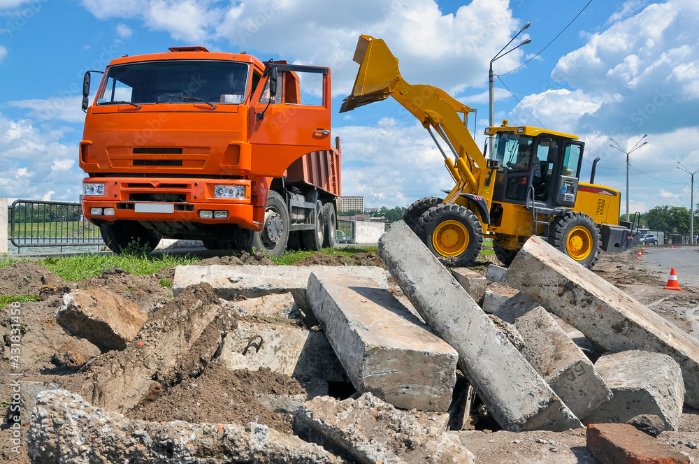 the tractor loads the soil into the dump truck. Construction of a new road. the tractor loads the soil into the dump truck. Construction of a new road.