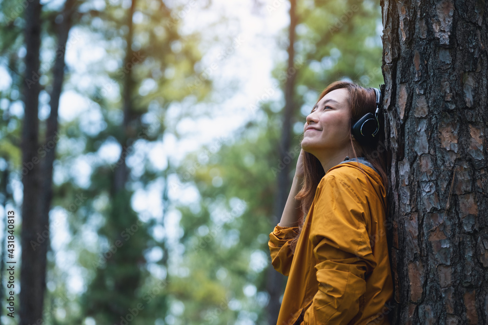 Portrait image of a beautiful young asian woman enjoy listening to music with headphone in the park Portrait image of a beautiful young asian woman enjoy listening to music with headphone in the park