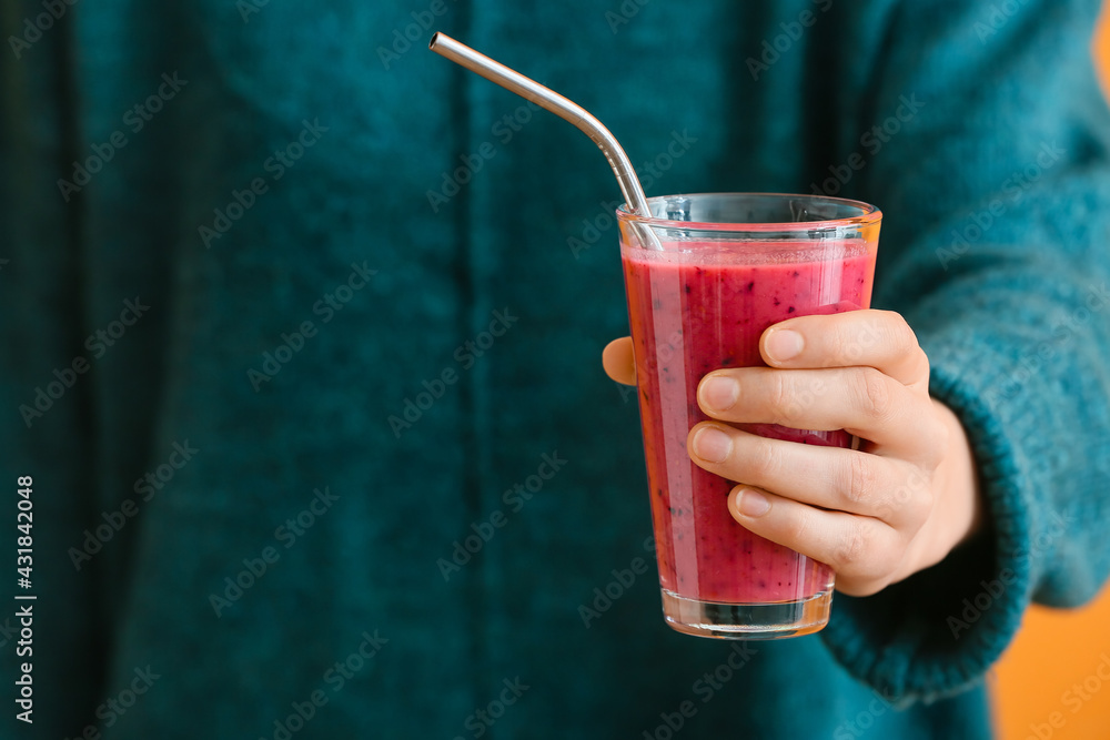 Woman with glass of fruit smoothie on color background - obrazy, fototapety, plakaty 